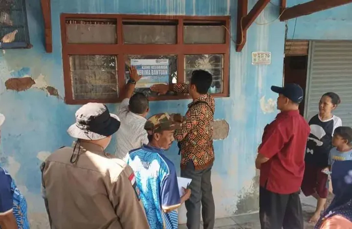 Petugas memasang stiker di rumah warga penerima bantuan sosial (bansos) di Kabupaten Majalengka sebagai bentuk transparansi dan pengawasan agar penyaluran bantuan tepat sasaran. (Foto: dok. Pikiran Rakyat)